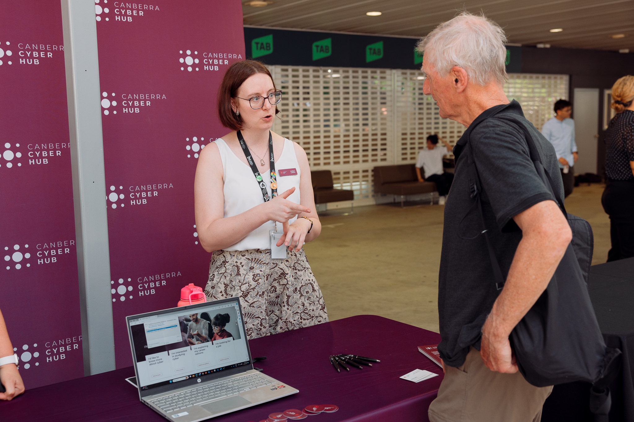 Melissa Larkins speaking to a man at a Canberra Cyber Hub event